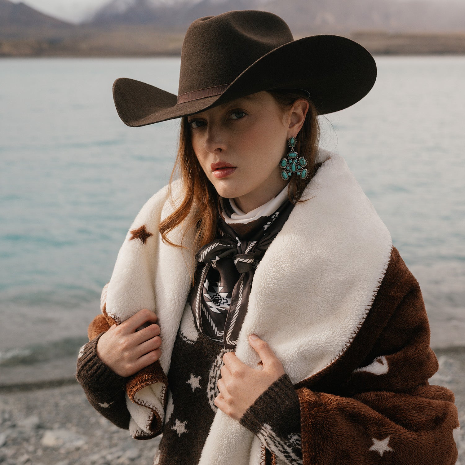 Woman wearing a cowboy hat by a lake