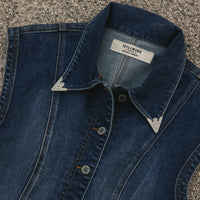 Blue denim shirt with collar and brand label on a textured surface